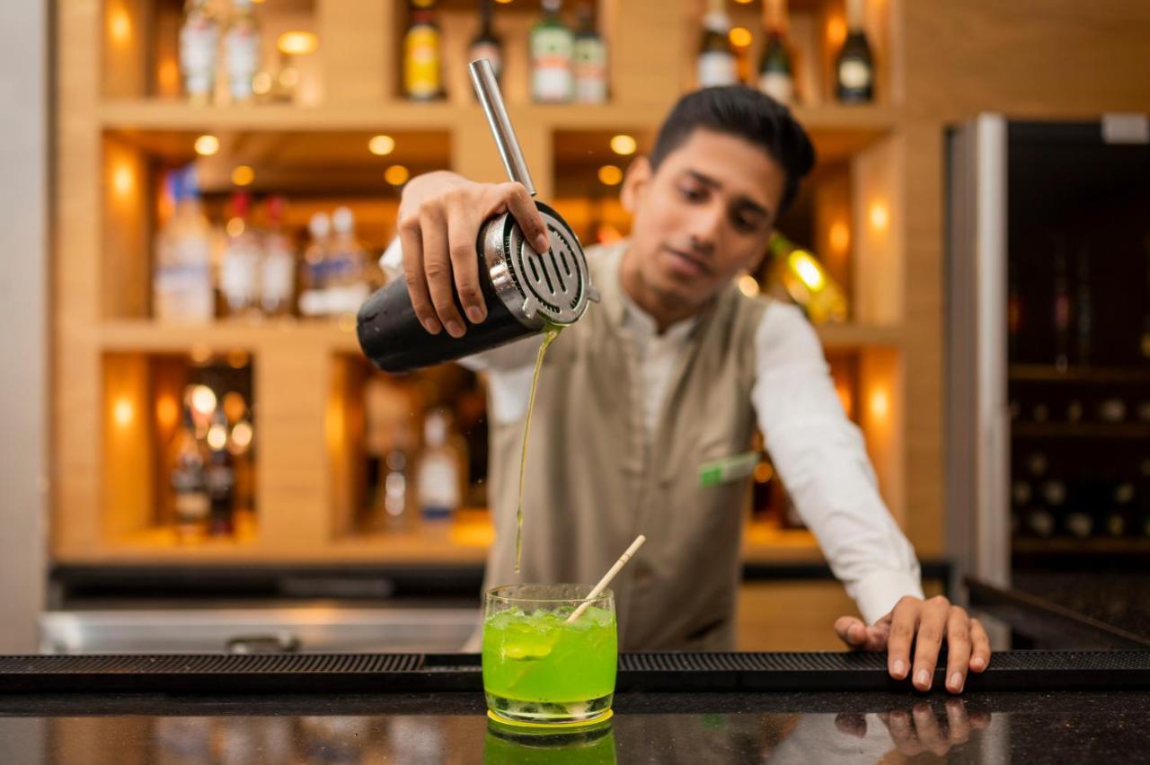 ホリデイ イン アーグラ Mg ロード エクステリア 写真 A bartender making a cocktail